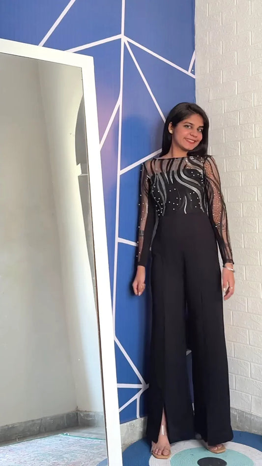 Black Jumpsuit with Sheer Long Sleeves and Intricate Silver Beaded Detailing, Featuring a Stylish High-Neck and Flared Pants with a Slit for a Modern